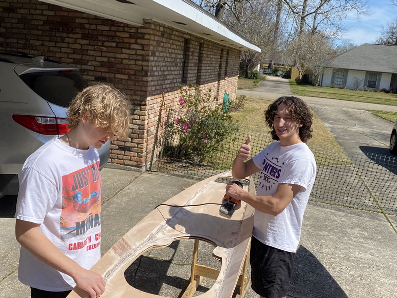 boys sanding underside of decks